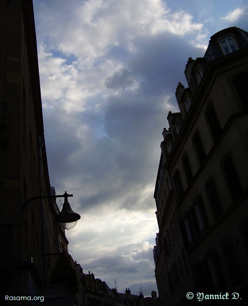 L’architecture
                de la rue dessine une virgule dans le ciel
            