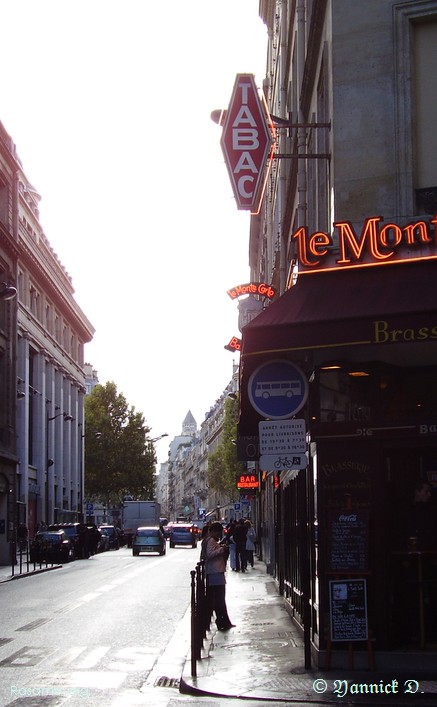 Une photographe glane
                pensive dans les rues de Paris
            